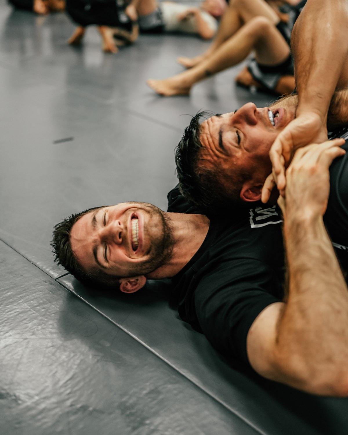 Johnny McEvoy mid-roll on the mats, grinning